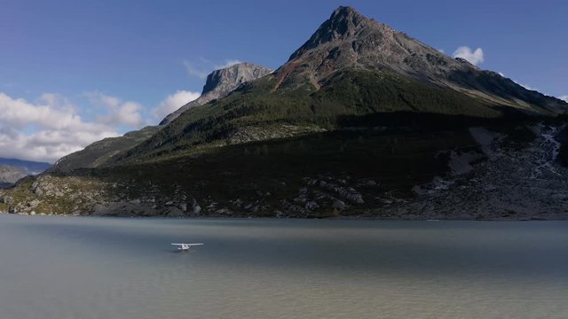 A drone shot of a Sea plane on a glacier lake in the mountains of British Columbia before take off