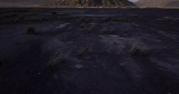 Mount Bromo, East Java, Indonesia. Aerial view Low angle tilt up reveal shot at Sunrise.