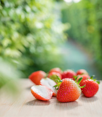 Fresh strawberries on the brown wooden table in garden, Red strawberry in farm on natural blur background