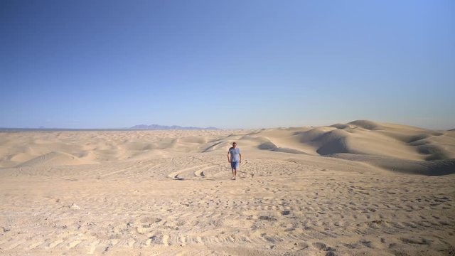 Man walking through Imperial Sand Dunes, Algodones Dunes, California