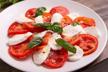 Italian Caprese dish with mozzarella cheese, fresh tomatoes, basil and extra virgin olive oil. Italian food, ideas for fast lunch, summer lunch.