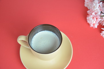 beige cup cappuccino beautiful white-pink aster flowers on a red background. good morning. greeting card. view from above. save space cookies macarune Mothers day or Womens day