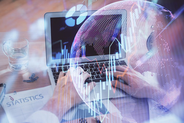 Multi exposure of market chart with man working on computer on background. Concept of financial analysis.