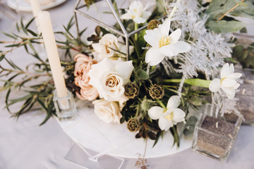 Stylish wedding floristics. Banquet tables decorated with arrangements of flowers, herbs and candles