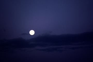 Big full moon on blue night sky.
