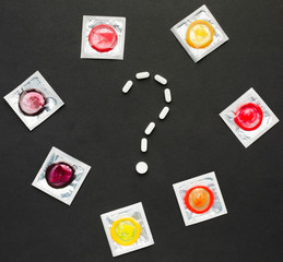 Question and doubt concept. Contraceptive pills and condoms.