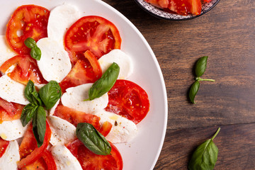 Italian Caprese dish with mozzarella cheese, fresh tomatoes, basil and extra virgin olive oil. Italian food, ideas for fast lunch, summer lunch.