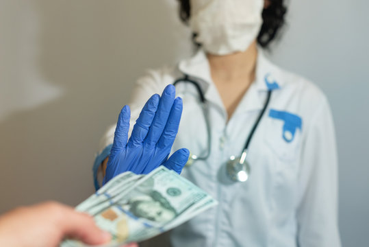 The doctor refuses the money from the patient. Bribe. Corruption in medicine, pharmaceuticals. The concept of paid medicine.