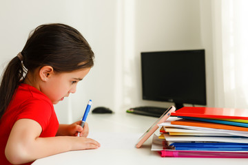 Distance learning online education, little girl writes formulas