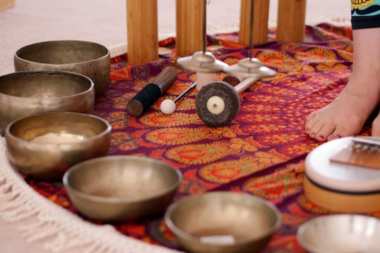 Tibetan singing bowls close up for a sound healing therapy session with other instruments in the background.