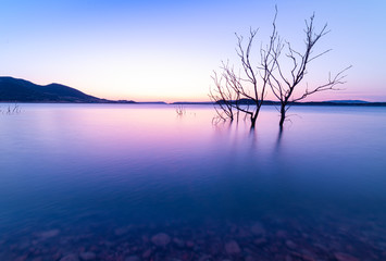 The last sunrays over a blue water mirror. Lake.