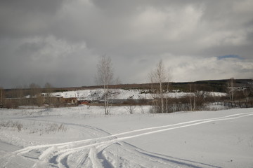 field in snow and cloudy sky