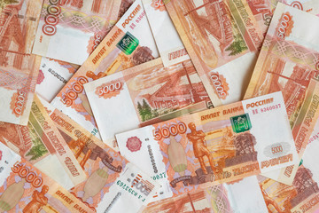 many banknotes with a face value of 5000 rubles are on the table, top view
