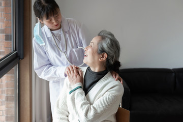 Obraz premium Young family doctor is talking with seniors