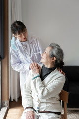 Obraz premium Young family doctor is talking with seniors