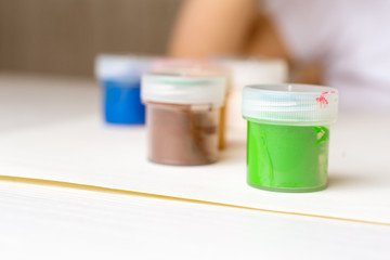 colored paints stand on the table green, blue, purple and others. stay home