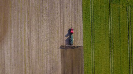 Traktor mit Güllefass und Schleppschuhverteiler auf einem Acker, Vogelperspektive