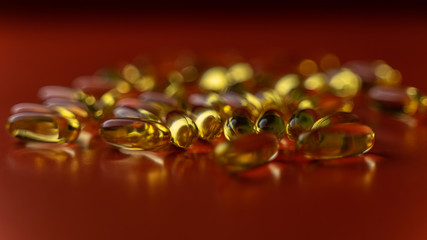 fish oil capsules on a red background close-up with a small roughness of sharpness. blurred background on the theme of health