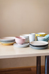Set of clean pastel ceramic crockery on wooden background. Color bowls, dishes. Top view