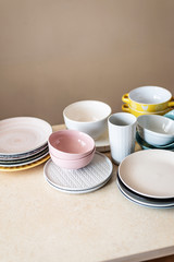 Set of clean pastel ceramic crockery on wooden background. Color bowls, dishes. Top view