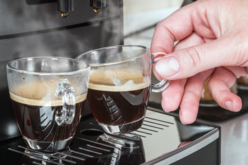 woman's hand takes a glass Cup of hot coffee