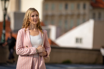 Young blonde woman exploring old town of Prague in sunny day, Czech republic