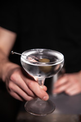 Fototapeta na wymiar bartender holds a glass with a drink