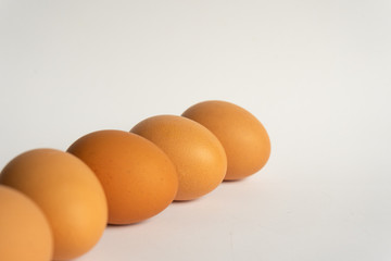 Five fresh brown chicken eggs in a row diagonally on grey background. Easter holiday