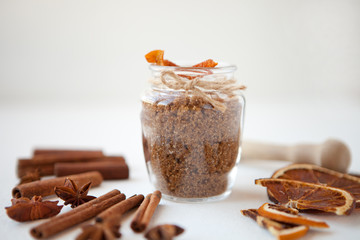 Cinnamon sticks, dried oranges and star anise with brown sugar bottle with shallow depth of field on white background. Baking ingredients