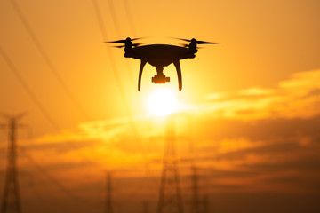 Fototapeta na wymiar Drone surveying High voltage towers the sunset background