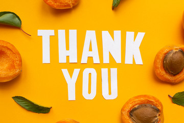  apricots and leaves with paper words. Thank you on orange paper