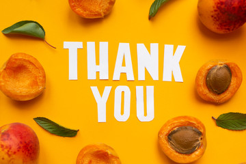  apricots and leaves with paper words. Thank you on orange paper
