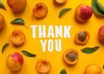  apricots and leaves with paper words. Thank you on orange paper