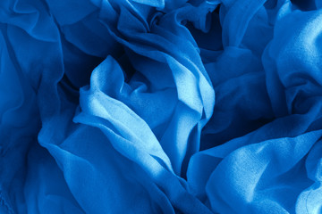 Texture of classic blue Wrinkled Fabric. Trendy color of clothes. Close-up.