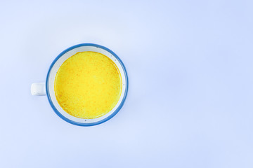 Golden milk in a Cup on a gray table with a copy space. Alternative medicine concept.