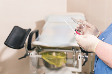 Close-up of doctor hand holds gynecological examination instruments. Gynecologist working in the obstetrics and gynecology department. Medical concept.