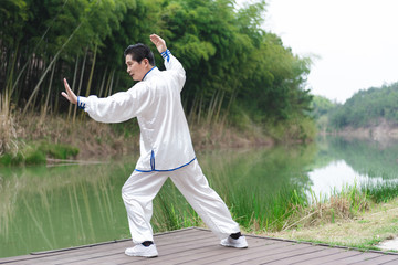An Asian elderly man doing sports by the lake