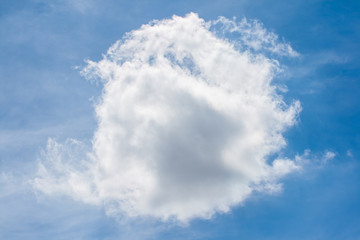 Large cloud formed in the sky surrounded by diffuse clouds and a blue sky in the background