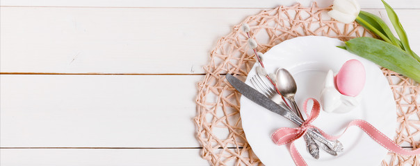 Easter background with pink Easter eggs, pussy-willow and cutlery. Top view, banner