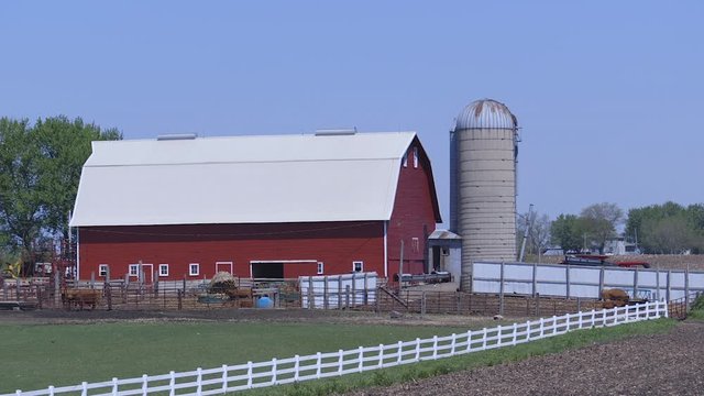 A red barn and silo on a farm in rural Iowa, USA