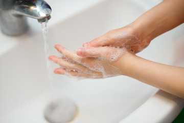 The girl washes her hands with antibacterial soap in the sink, protection against Covid 19 viruses, health care, protection against coronovirus, skin cleansing, prevention of viral diseases