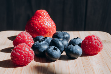 juicy fresh berries blueberries and raspberries are on the wood table