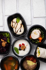 School lunch box with soup, vegetables, curds dessert and salad. First meal concept