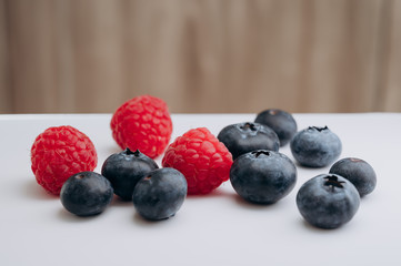 juicy fresh berries blueberries and raspberries are on the white table