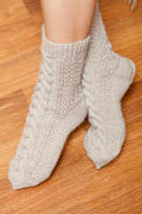 pair of knitted woolen socks on woman's feet