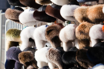 a lot of earflapped fur hats in the market