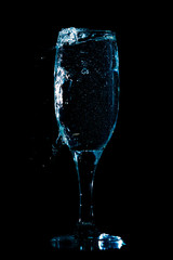 A glass of water is isolated on a black .