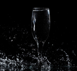 Splashes and drops of water in a glass are isolated on a black .
