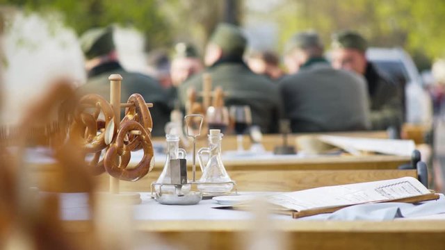 Close-up salted pretzels put on table on wooden stand in traditional alsatian outdoor cafe and old newspaper as decoration for historical film about world war