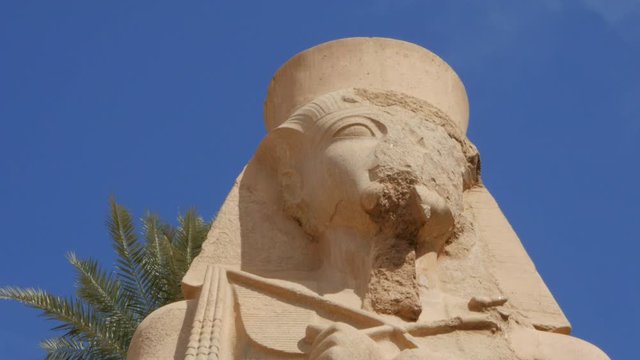 There is a Stunning Work of Art - Two Statues of Pharaohs, One of Them is Small and the Second One is Large. They Are Located One Over Another. The Small Statue Has a Crown on Its Head.